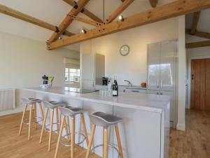 una cucina con una grande isola con sgabelli da bar di South Barn Cottage a Faringdon