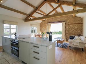 una cucina con armadi bianchi e un muro in pietra di South Barn Cottage a Faringdon Altre 29 foto