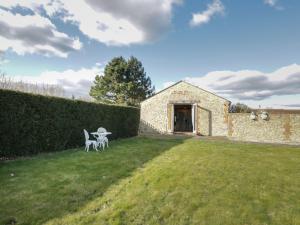 un giardino con tavolo e sedie in un cortile di South Barn Cottage a Faringdon