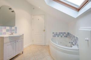 Un baño con bañera blanca y lavabo. en Annedd Lon, en Abersoch 31 fotos más