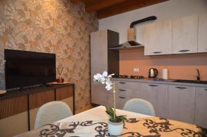 a kitchen with a table with chairs and a television at Ca Vellione cozy apt Noale in Noale