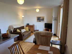 a living room with a couch and a table at Alices’s Beachside Haven in Harwich