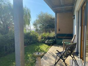 a patio with two chairs and a table on a porch at Alices’s Beachside Haven in Harwich +18 photos