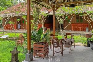 Un patio con mesa y sillas y una casa. en Carla Garden, en Yogyakarta