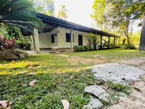 a small white house with a large yard at Green Agua Lodge in Belihul Oya