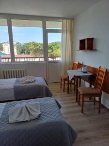 a hotel room with two beds and a table and chairs at ORW Rzemieślnik in Międzywodzie