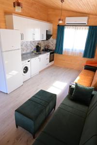 a living room with a couch and a kitchen at Cirali Zambak Villa in Cıralı