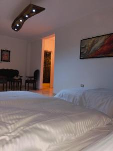 a bedroom with a white bed and a dining room at Rafif hotel in Cairo