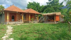 une petite maison avec un toit en gazon dans l'établissement De Sudi Bungalows, à Pemuteran 11 autres photos
