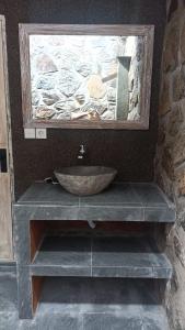 une salle de bain avec un lavabo et un miroir dans l'établissement De Sudi Bungalows, à Pemuteran