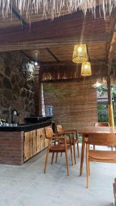 une cuisine avec une table, des chaises et un comptoir dans l'établissement De Sudi Bungalows, à Pemuteran