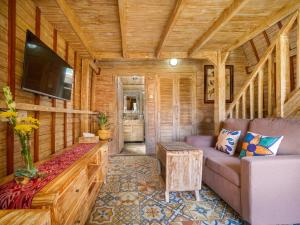 a living room with a couch and a tv in a cabin at Wisnu Lumbung Uluwatu in Uluwatu