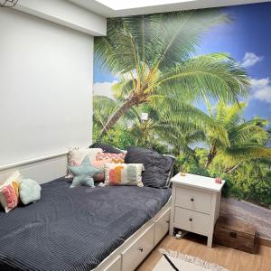 - une chambre ornée d'une fresque murale représentant un palmier dans l'établissement Jolie villa Bali-style, à Marseille