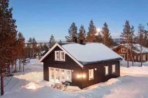 a small house with snow on the roof at New big cabin near the city centre! in Røros