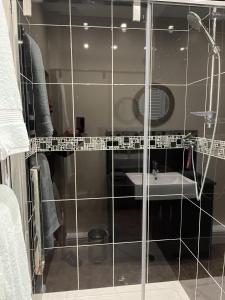 a bathroom with a shower and a sink at Haven Hideaway by the Sea in Harwich