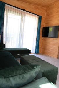 a living room with two beds and a flat screen tv at Cirali Zambak Villa in Cıralı