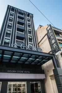 un bâtiment avec un panneau indiquant l'hôtel en pierre dorée dans l'établissement Golden Stone Hotel, à Kaohsiung