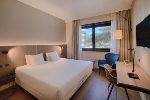 a hotel room with a large white bed and a desk at NH Roma Villa Carpegna in Rome