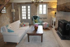 a living room with a couch and a coffee table at A Charming Countryside Retreat Le Mas No 14 in Ayen