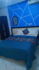 a blue bedroom with a bed with a blue wall at Complexe A8CLOS in Douala