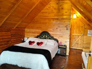 een slaapkamer met een bed met twee rode harten erop bij Glamping El Ocaso in Zipaquirá