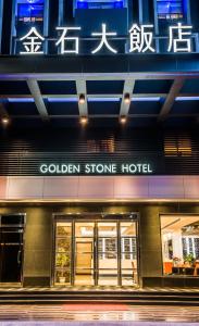 uma loja em frente a um hotel de pedra dourada à noite em Golden Stone Hotel em Kaohsiung