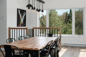 a dining room with a wooden table and chairs at Chalet Mysa Spa Lac access Firepit pit SKI in Saint Come