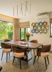 a dining room with a wooden table and chairs at Vilmaris Luxury Villas in Saligao +6 photos