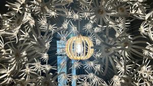 un lustre suspendu au plafond d'un bâtiment dans l'établissement Résidence cosy Les Ambassadeurs - Centre Ville Aix les Bains, à Aix-les-Bains