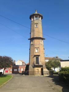 a tall brick tower with a fence around it at Bakehouse in Harwich