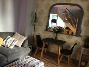 a living room with a couch and a table with a mirror at The Bakehouse in Harwich