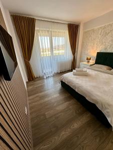 a bedroom with a large bed and a large window at Sofia Residence Apartments Cetate in Târgu Neamț +30 photos