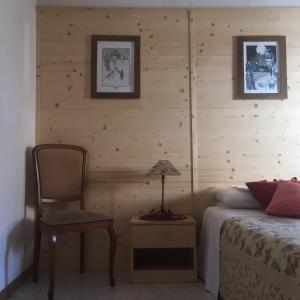 a bedroom with a bed and a chair and a lamp at Casa di Nonno Tilio in Priola