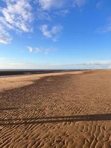 a beach with a shadow on the sand at Golden Sands 8 berth cosy caravan in Rhyl +3 photos