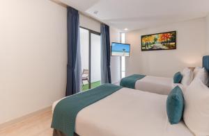 a hotel room with two beds and a tv at Ocenami Resort 3 pn in Long Hai