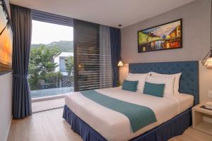a bedroom with a large bed with a large window at Ocenami Resort 3 pn in Long Hai +93 photos