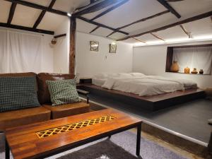a bedroom with a bed and a couch and a table at Green Casa in Seogwipo +35 photos