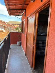 an orange building with a door and a balcony at Flat Bonito Jarinu 02 Centro in Bonito