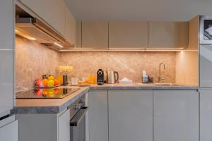 a kitchen with white cabinets and a bowl of fruit at Louren Apartments in Prague
