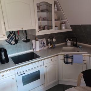 a kitchen with white cabinets and a sink at Ferienwohnung Emma in Leer +55 photos