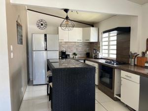 a kitchen with white cabinets and a black counter top at Maison Cambuston in Saint-André