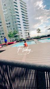 a man sitting in front of a swimming pool at Cosy Uptown 2 Bedroom Sandton in Johannesburg