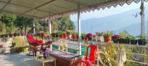 a balcony with chairs and a table and potted plants at Namo Homestay in Sosing