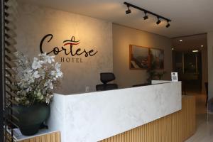 un ricevimento di un hotel caffè con un vaso di fiori di HOTEL CORTESE a Teresina