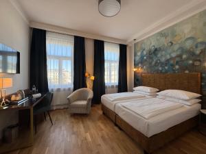una camera da letto con un letto, una scrivania e finestre di Hotel Secession an der Oper a Vienna