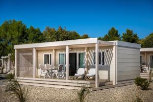 冯塔纳Maistra Camping Valkanela Mobile homes的配有桌椅的大型白色棚屋