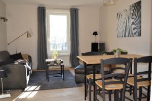 a living room with a table and chairs and a couch at Appart'hôtel 27 le lion d'or in Malaucène