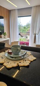a table with a cup and a plate of food at Studio Pomerode in Pomerode