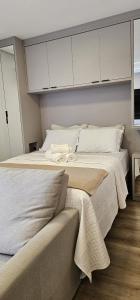 a bedroom with two beds with white cabinets at Studio Pomerode in Pomerode