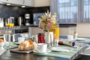 a table with a vase of flowers and bread on it at Apartment B10 "Südbalkon mit Haffblick" im Pine Hill Resort in Zirchow